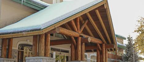 A lodge with a snow-covered roof and stone pillars.