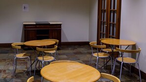 A room with multiple round tables and chairs, a wooden cabinet, and a tiled floor. - SW Hotel – No Resort Fee (San Francisco)