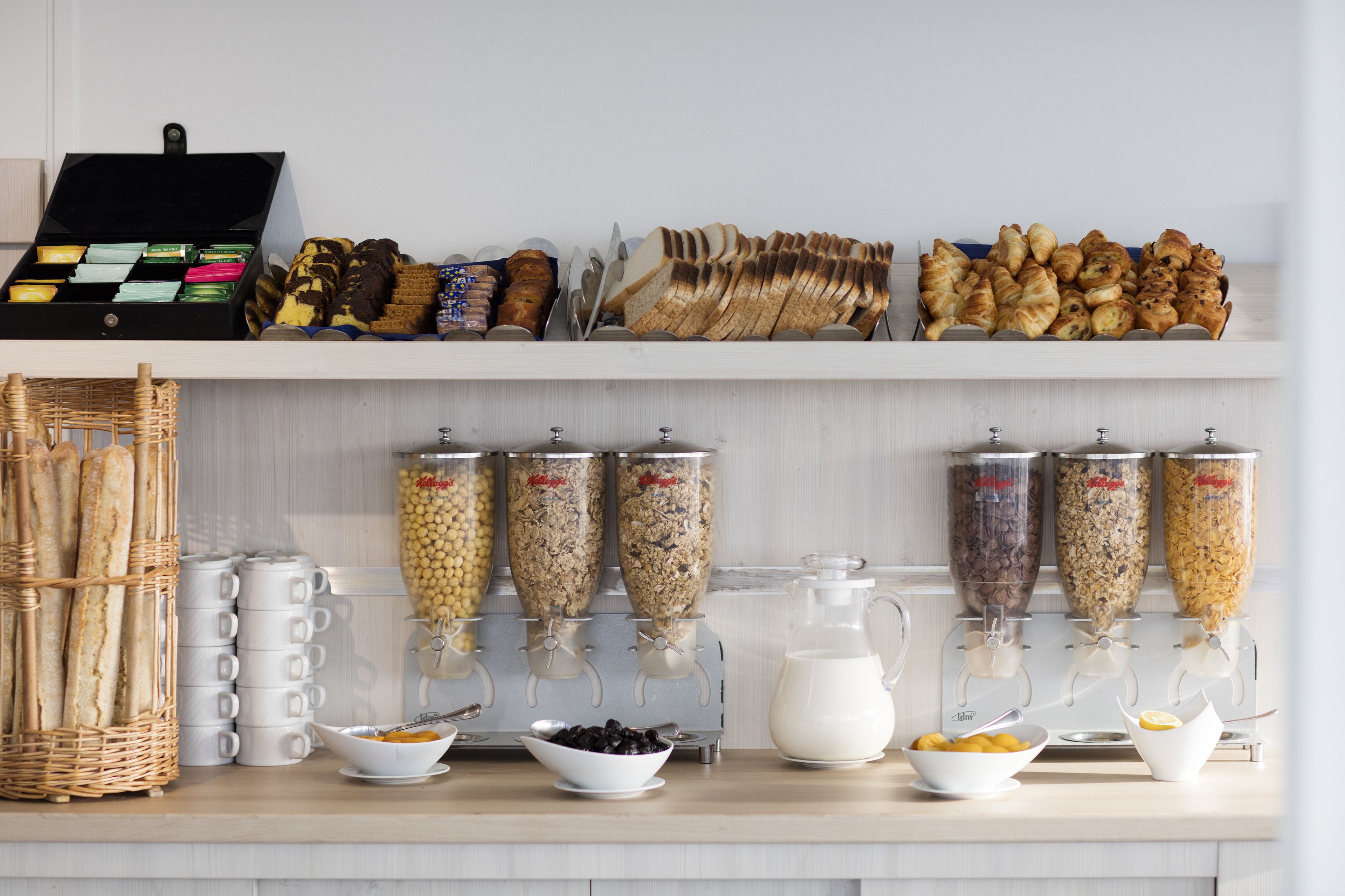 Een ontbijtbuffet met diverse soorten eten, zoals brood, gebak en cornflakes.
