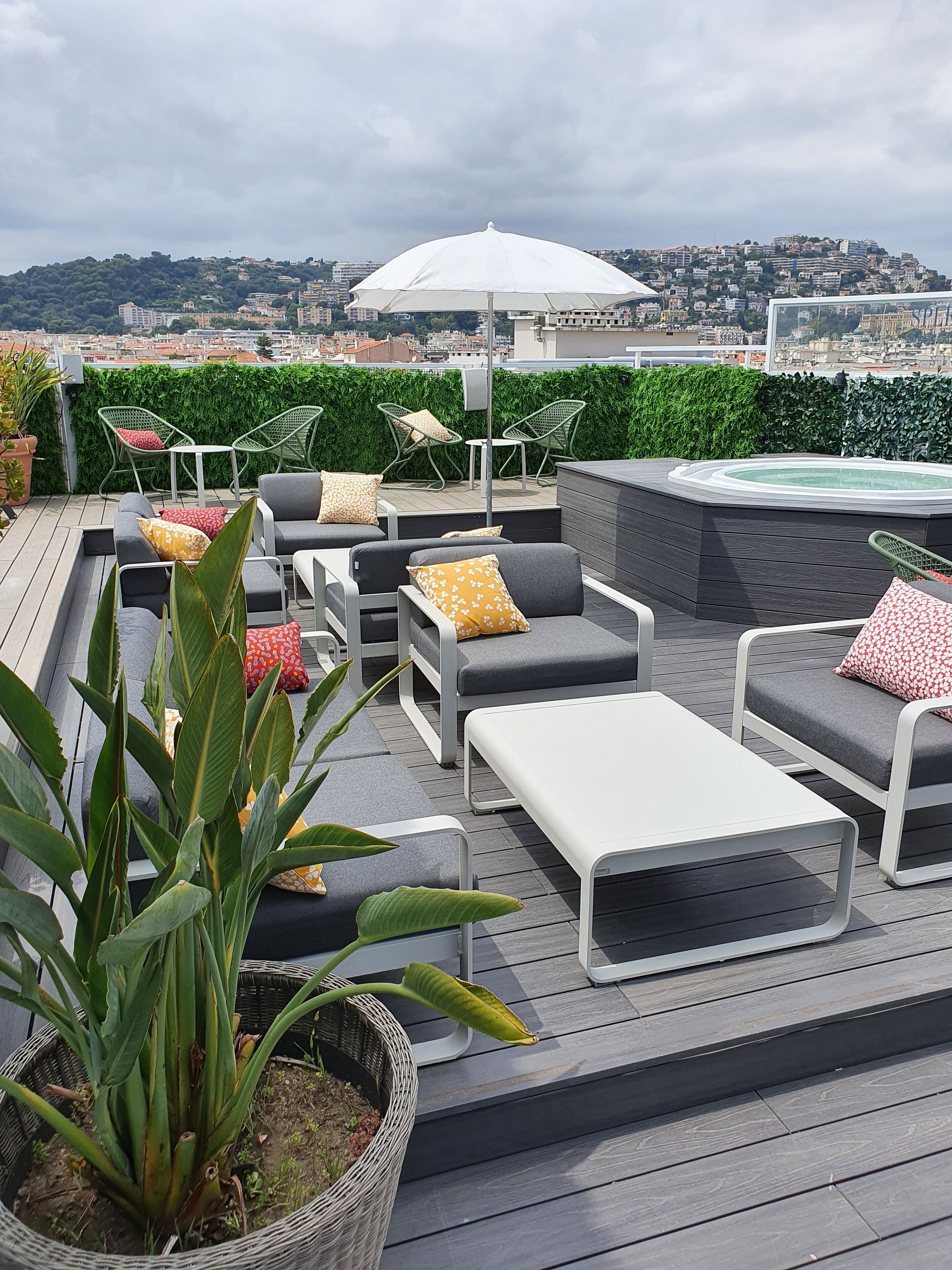Une terrasse sur le toit avec des sièges extérieurs, un jacuzzi et une vue sur la ville.