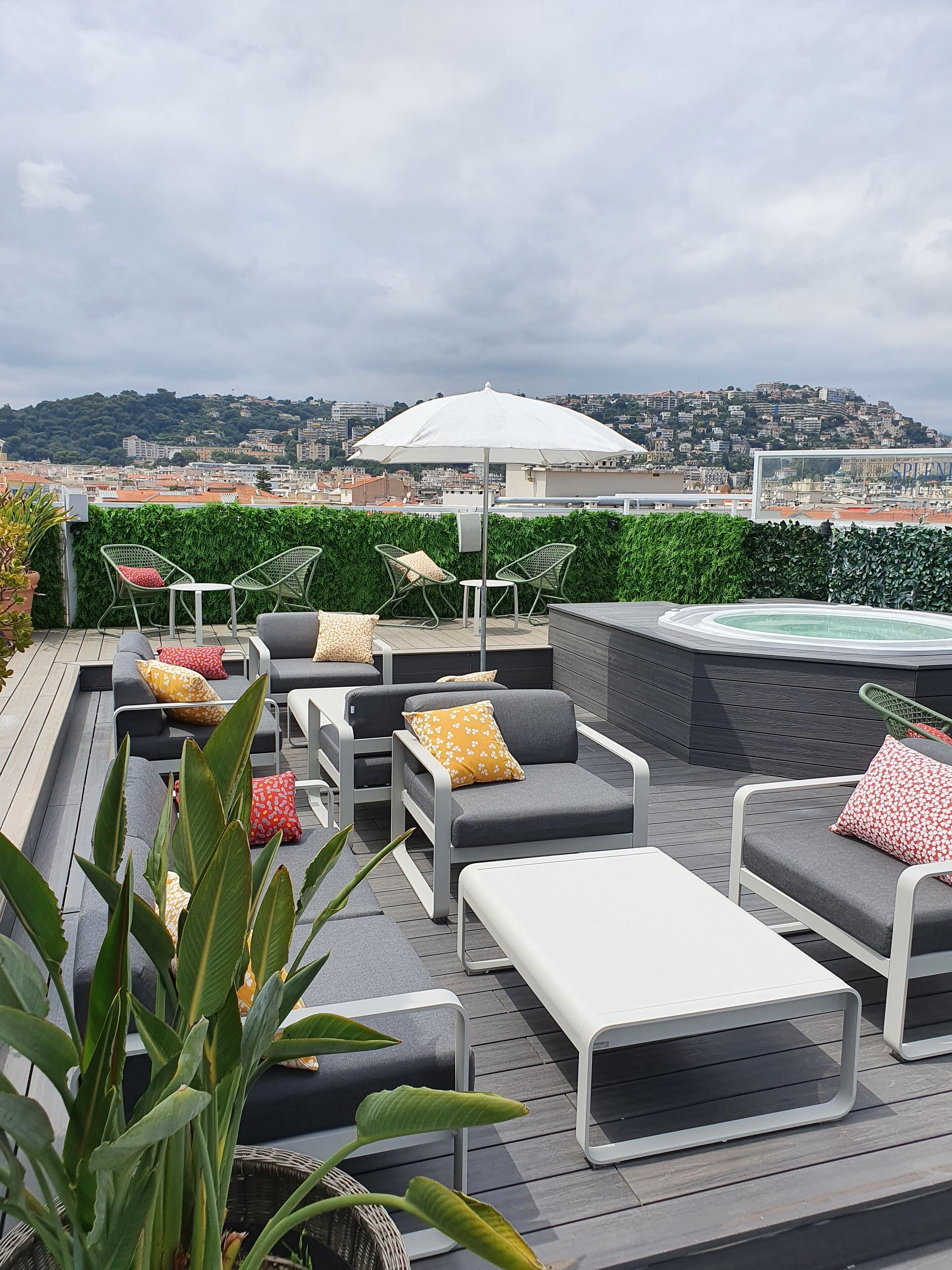 A rooftop terrace with outdoor seating, a hot tub, and a city view.