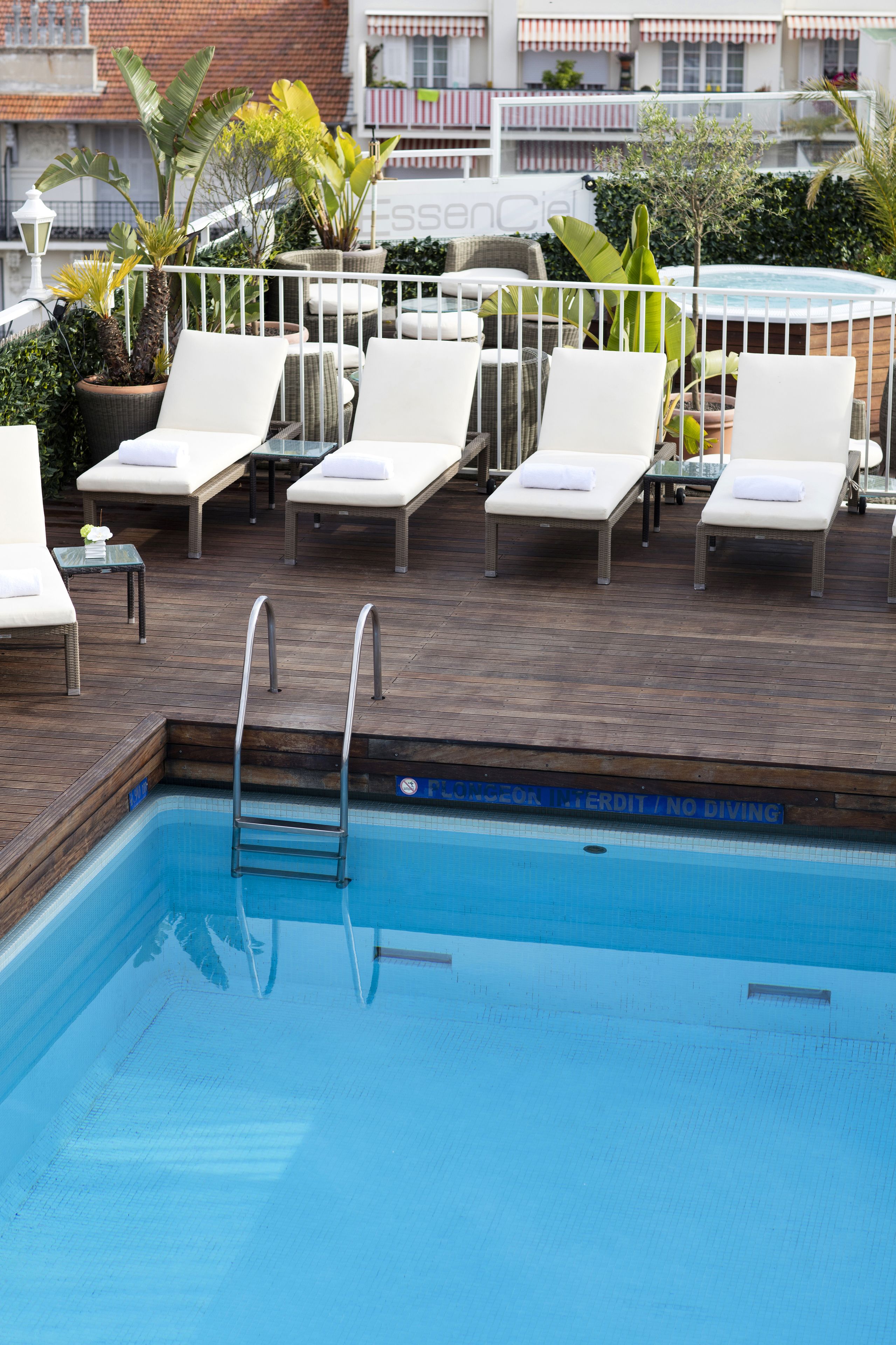 A poolside area with lounge chairs and a pool.