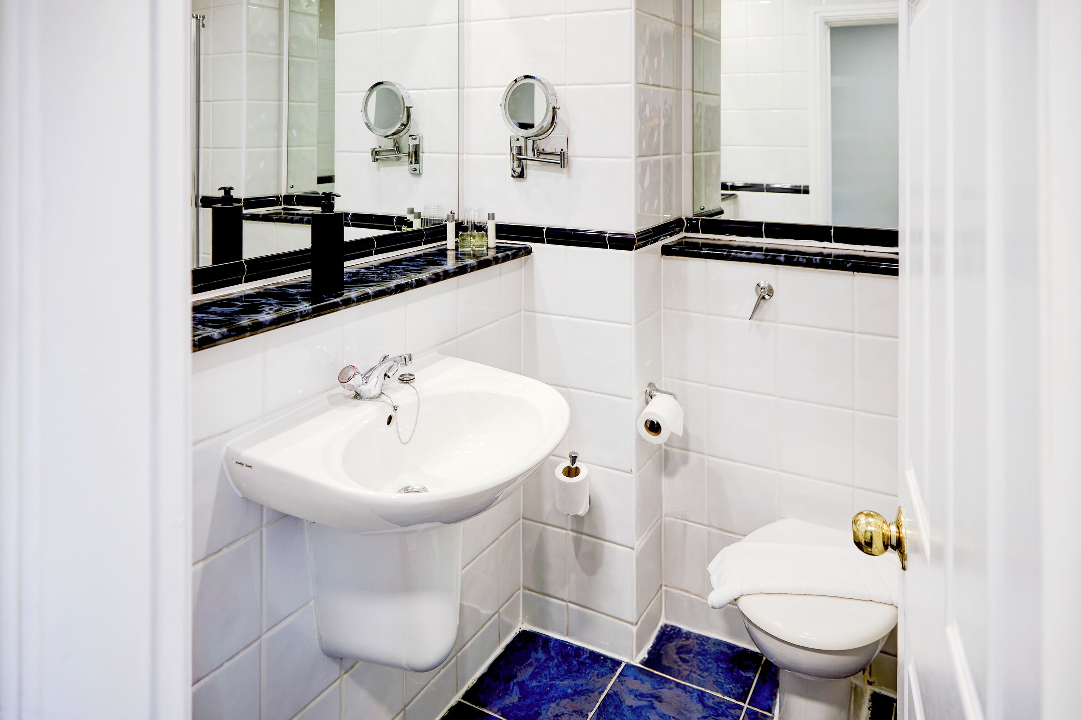 A bathroom with a white sink, a mirror, and a toilet.