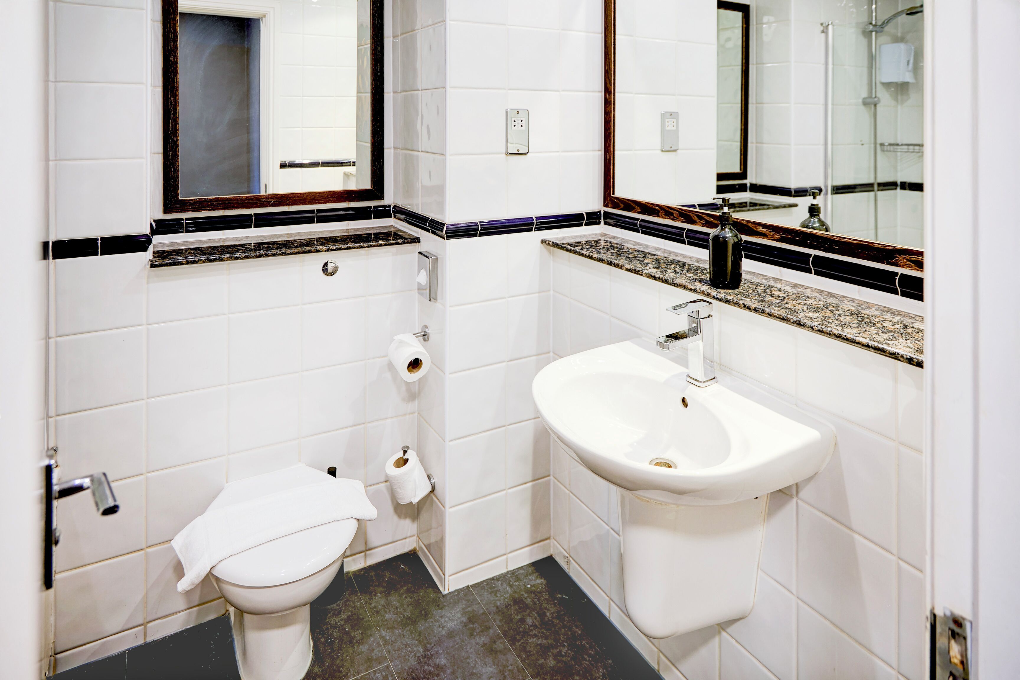 A bathroom with a white toilet, a sink, and a mirror.