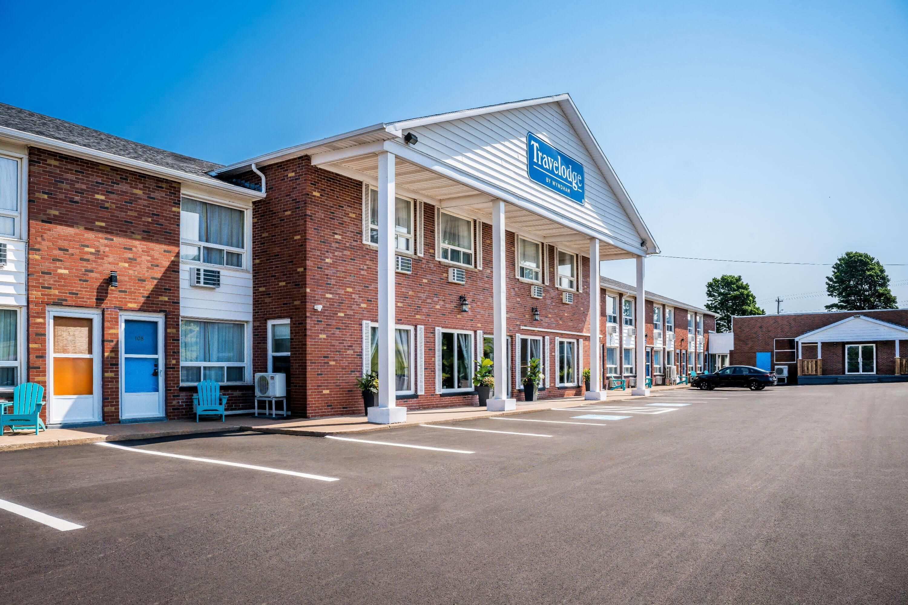 A Travelodge hotel with a brick facade, multiple windows, and a covered entrance.