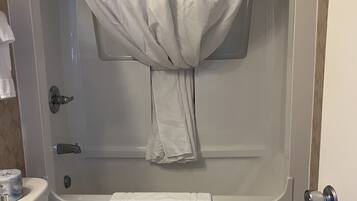 Een badkamer met douchegordijn, toilet en wastafel.