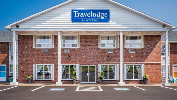 A Travelodge by Wyndham hotel with a brick facade, multiple windows, and a parking lot.