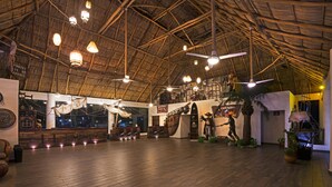 A spacious indoor area with a high ceiling and wooden beams, featuring a large wooden ship model, various nautical decorations, and a sign welcoming visitors. - Vista Playa de Oro Manzanillo (Manzanillo)