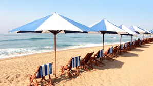 A beach with rows of beach chairs and umbrellas aligned along the shore. - Vista Playa de Oro Manzanillo (Manzanillo)