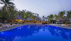 A pool area with lounge chairs and thatched-roof structures, surrounded by palm trees. - Vista Playa de Oro Manzanillo (Manzanillo)