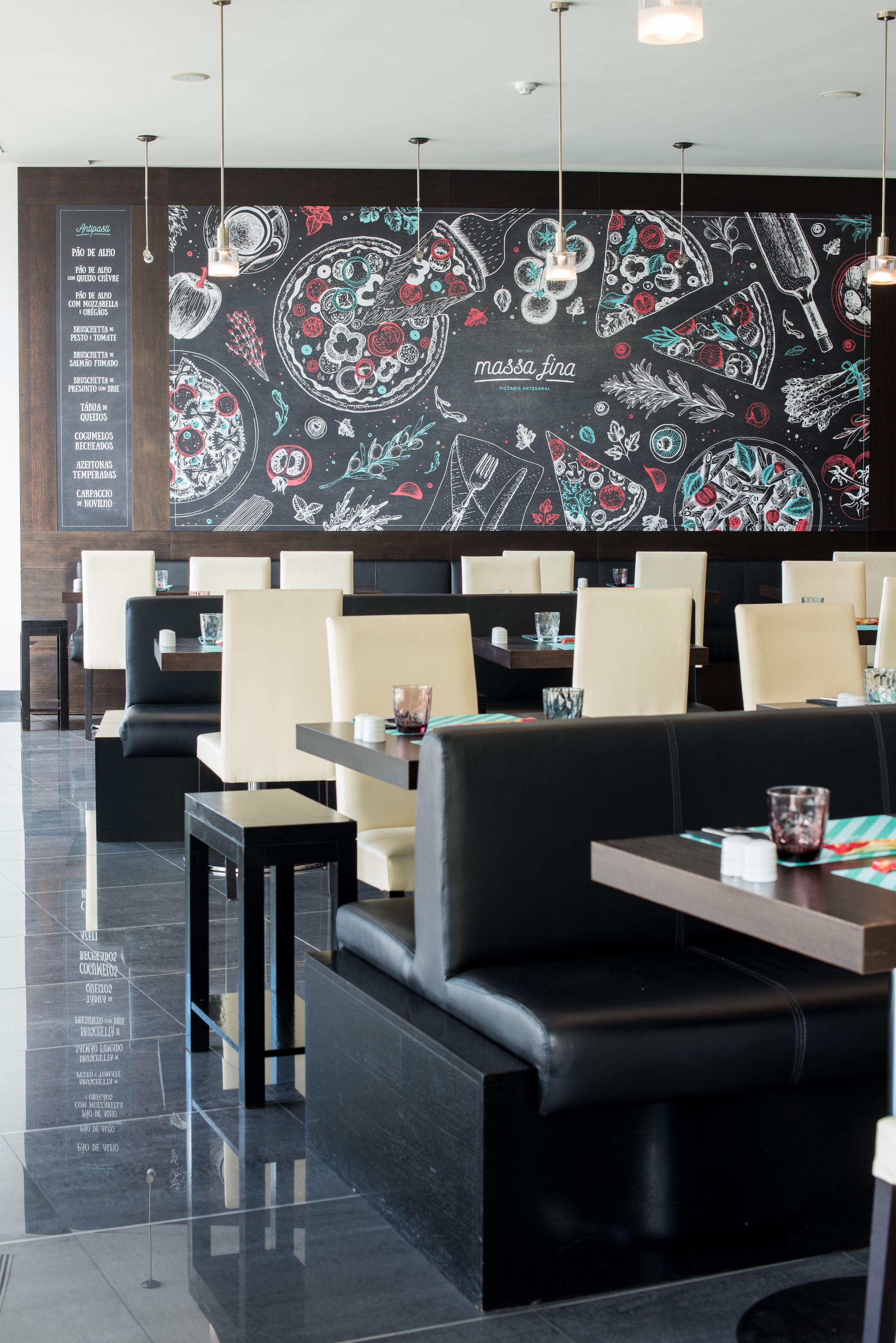 En restaurang med svart- och vitrandiga väggar, flera sittområden och en menytavla på vänster sida.