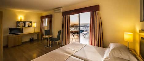 Habitación de hotel con cama, escritorio, silla y vista a la ciudad.