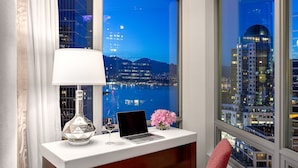 A modern office with a desk, laptop, lamp, and chair, overlooking a cityscape at night. - Auberge Vancouver Hotel (Vancouver)