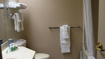 A bathroom with a toilet, sink, and a shower area.