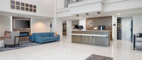 A spacious lobby with a blue sofa, a reception desk, and a modern design.