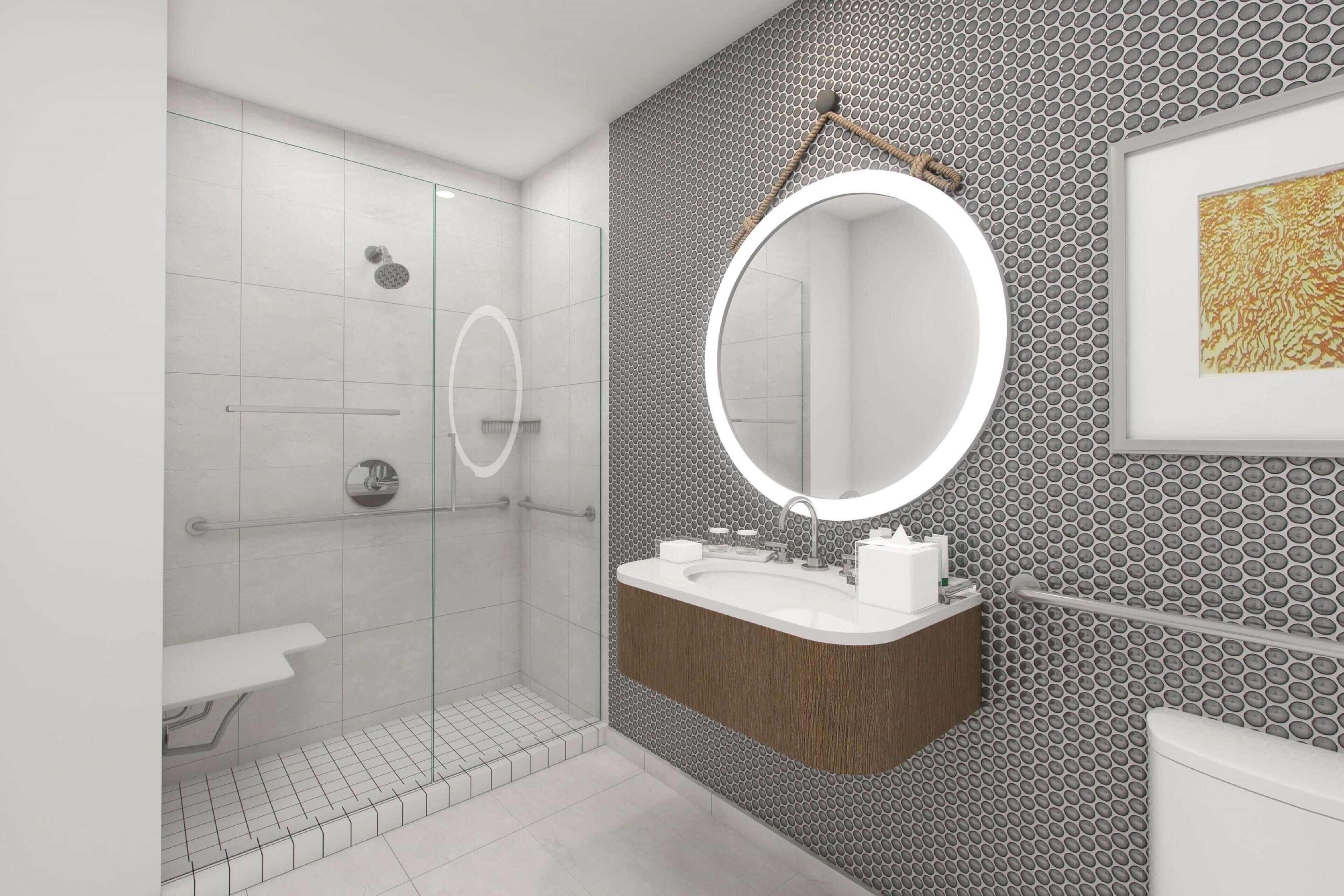 A modern bathroom with a glass shower enclosure, a wooden vanity, and a large mirror.