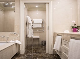 A modern bathroom with a walk-in shower, a bathtub, a toilet, and a vanity with a sink and mirror.