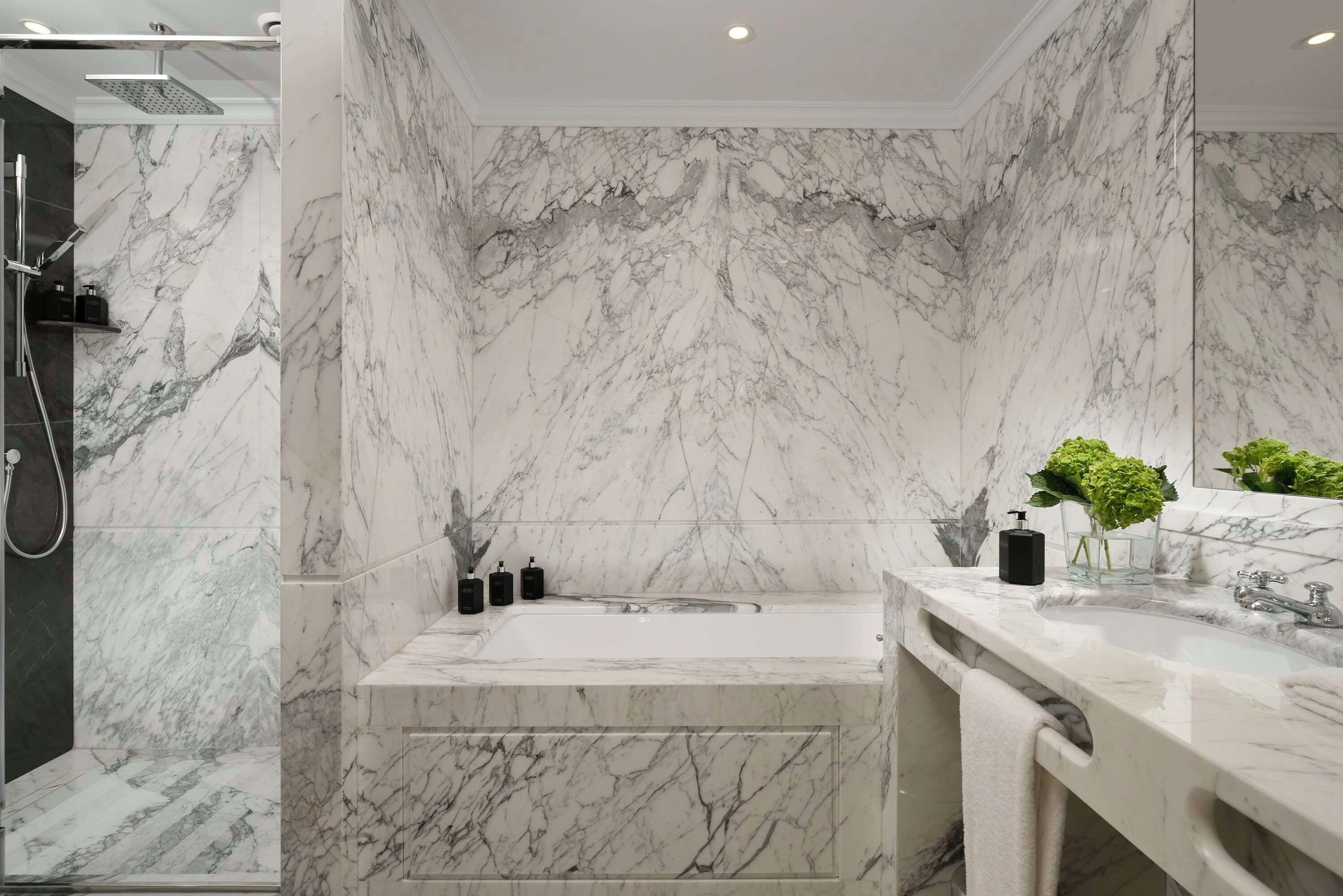 Une salle de bain moderne avec un mur en marbre, une baignoire et une douche.
