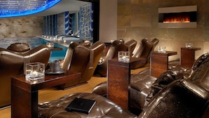 Un salón moderno con sofás de cuero, una piscina y una chimenea.