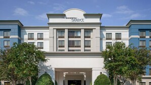 A hotel with a modern facade, a central entrance, and symmetrical landscaping. - Sonesta Select Nashville Airport Suites (Nashville)