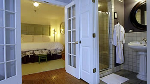 A bathroom with a shower, a sink, and a mirror. - Fife And Drum Inn (Williamsburg)