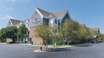 Un hotel con diseño arquitectónico moderno, destacando un cartel prominente de 'Candlewood Suites'.