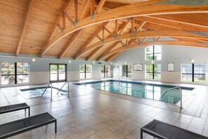 Una piscina techada, sillones reclinables de piscina