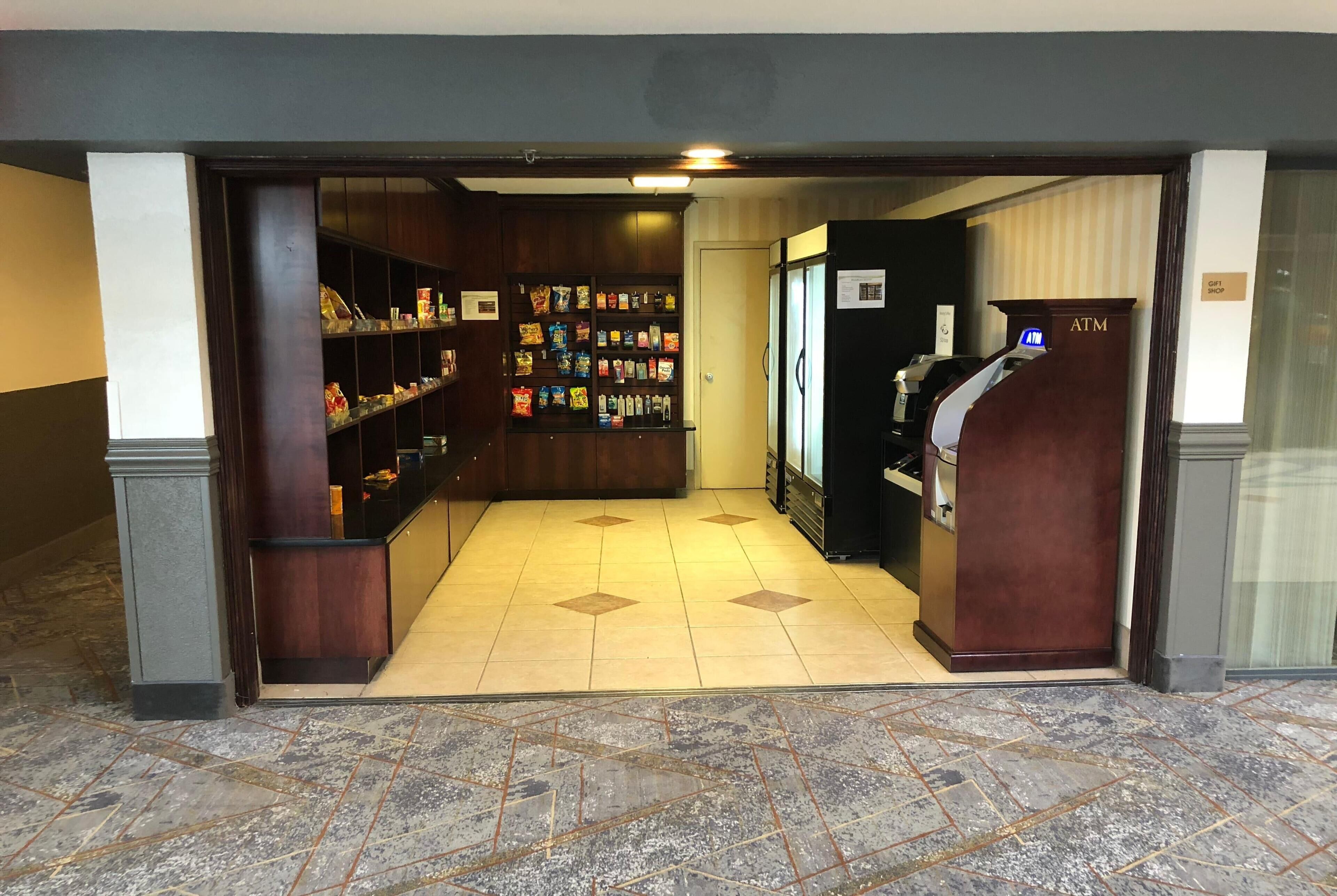 Un hall con una barra de aperitivos, un cajero automático y una recepción.