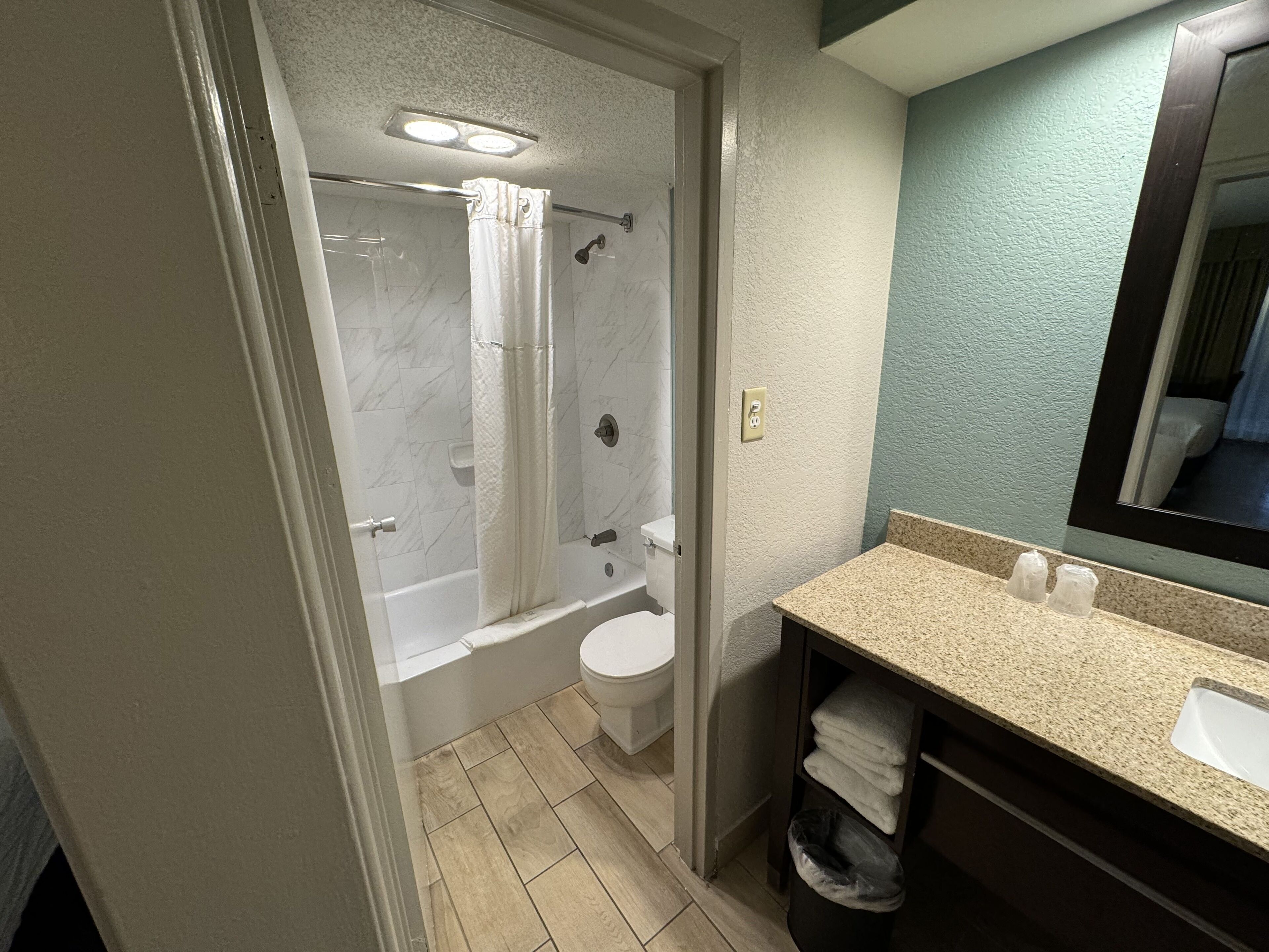 A bathroom with a shower, toilet, and sink.