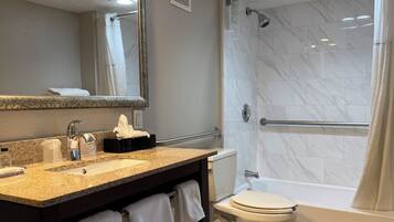 Une salle de bain équipée d’un lavabo, d’un miroir, d’un porte-serviettes, de toilettes et d’une douche.