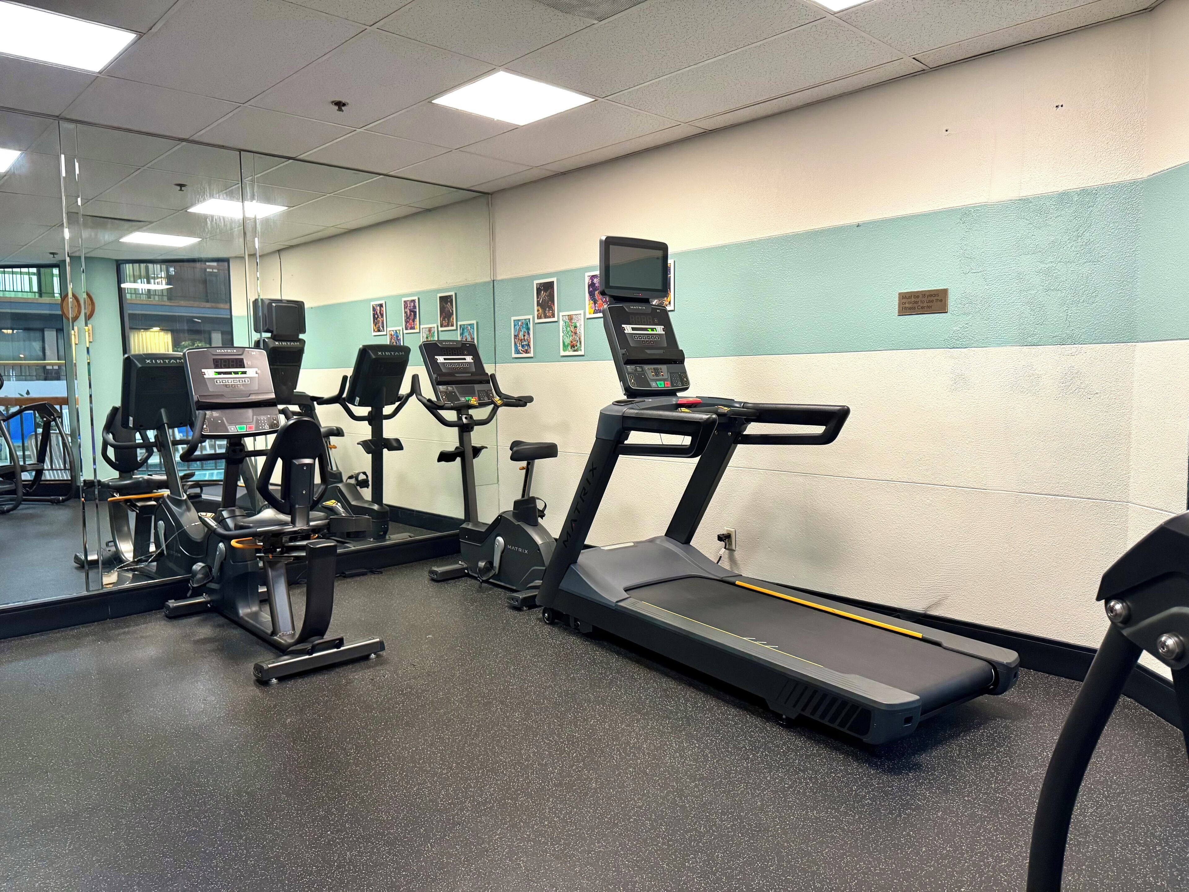 A gym with treadmills, stationary bikes, and elliptical machines.