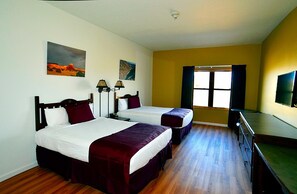 Two single beds with white linens and dark red bedspreads, each flanked by a nightstand with a lamp.