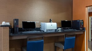 A bar area with three computers, a printer, and a phone. There are two blue bar stools. - Comfort Inn Garner Clayton I-40 (Garner)