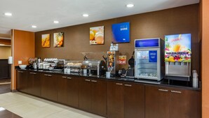 A breakfast bar with coffee machines, waffle makers, and a juice dispenser. - Comfort Inn Garner Clayton I-40 (Garner)