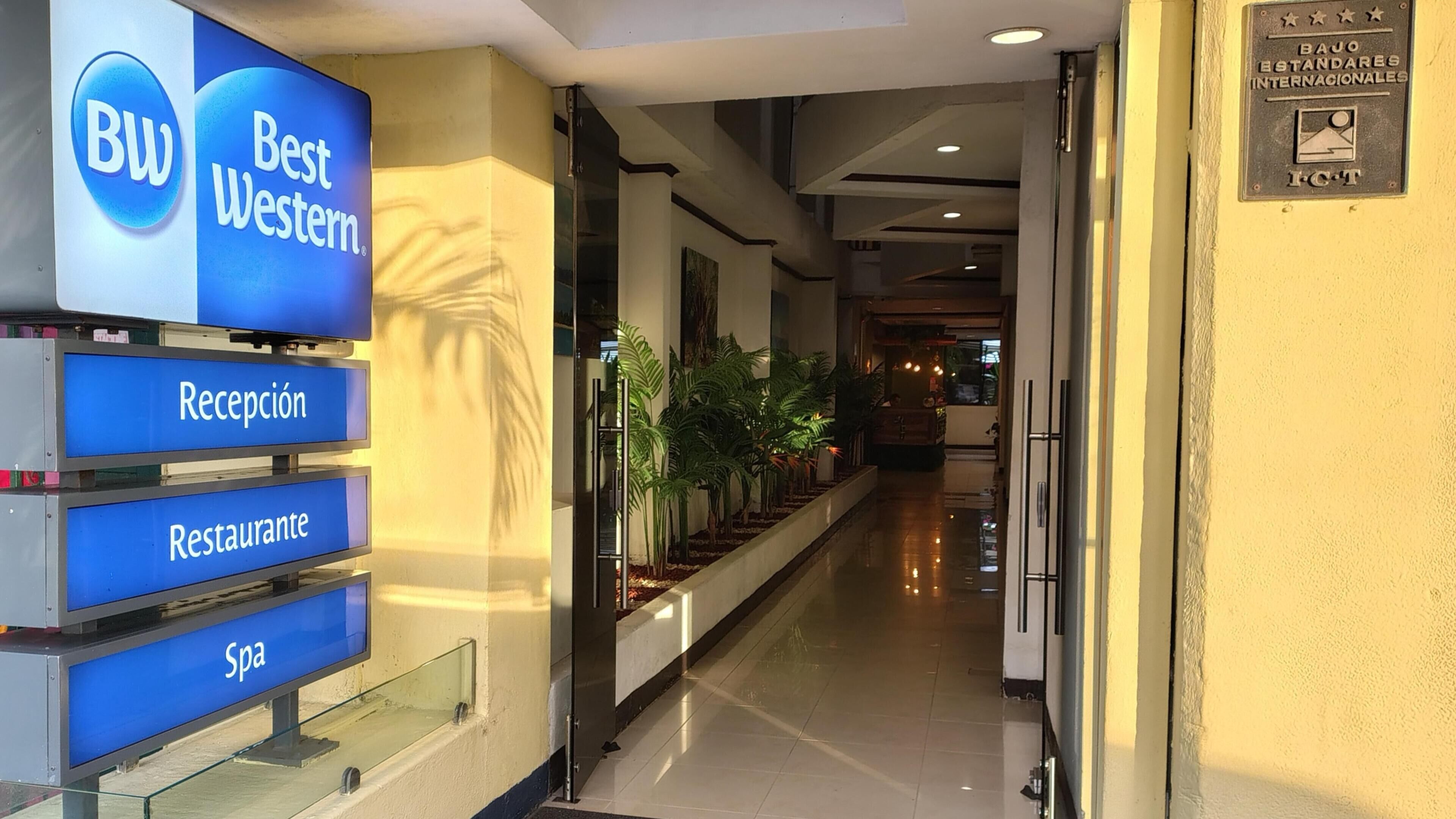 A hotel reception area with a Best Western sign, reception, restaurant, and spa services.
