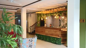 A reception area with a wooden desk, green wall, and a staircase. - Best Western Hotel & Casino Kamuk (Quepos)