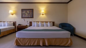 Een hotelkamer met twee bedden, een bureau, een stoel en twee wandlampen.