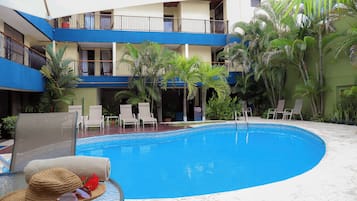 Een buitenzwembad en ligstoelen