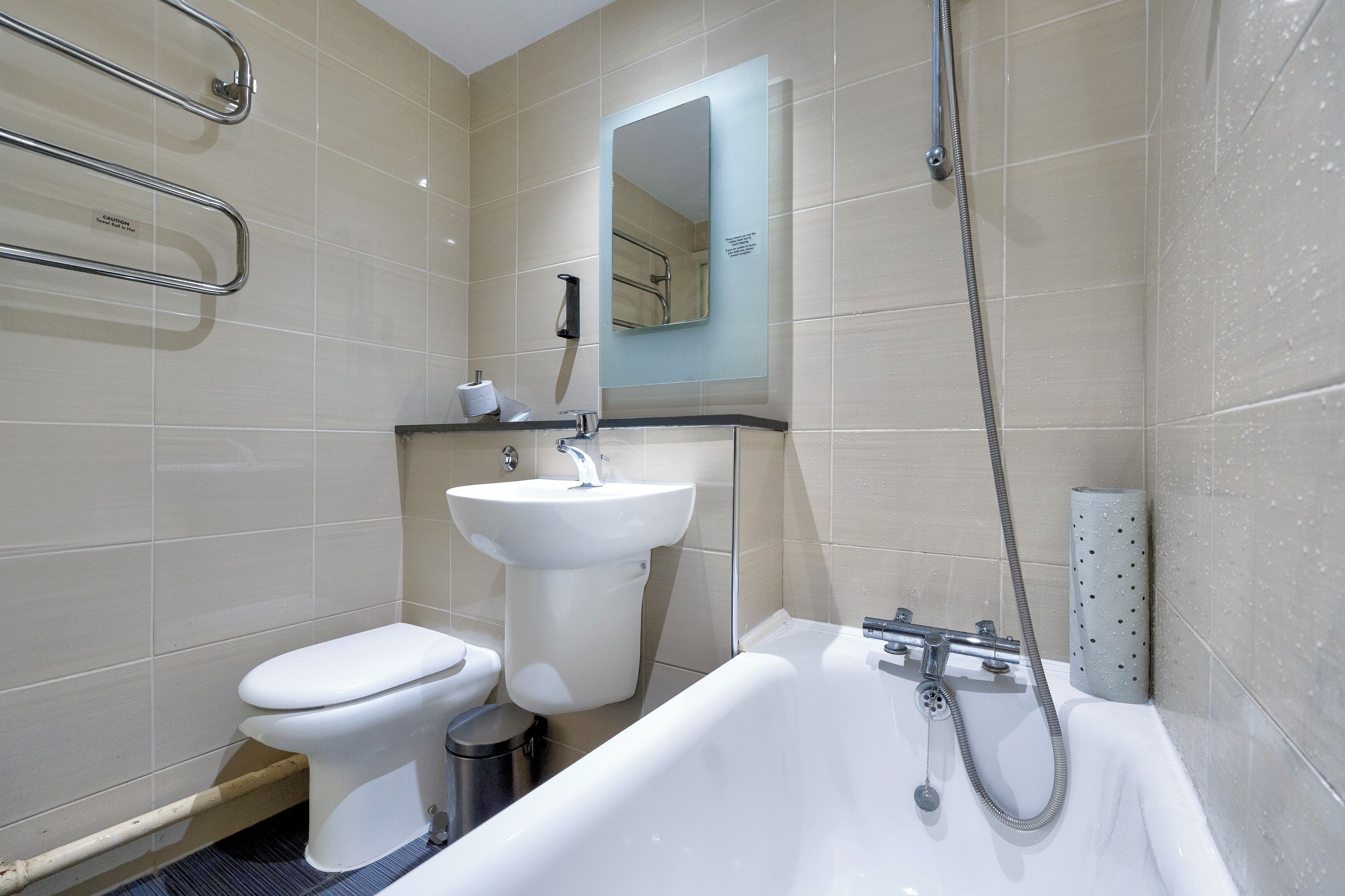 A modern bathroom with a toilet, sink, and bathtub.