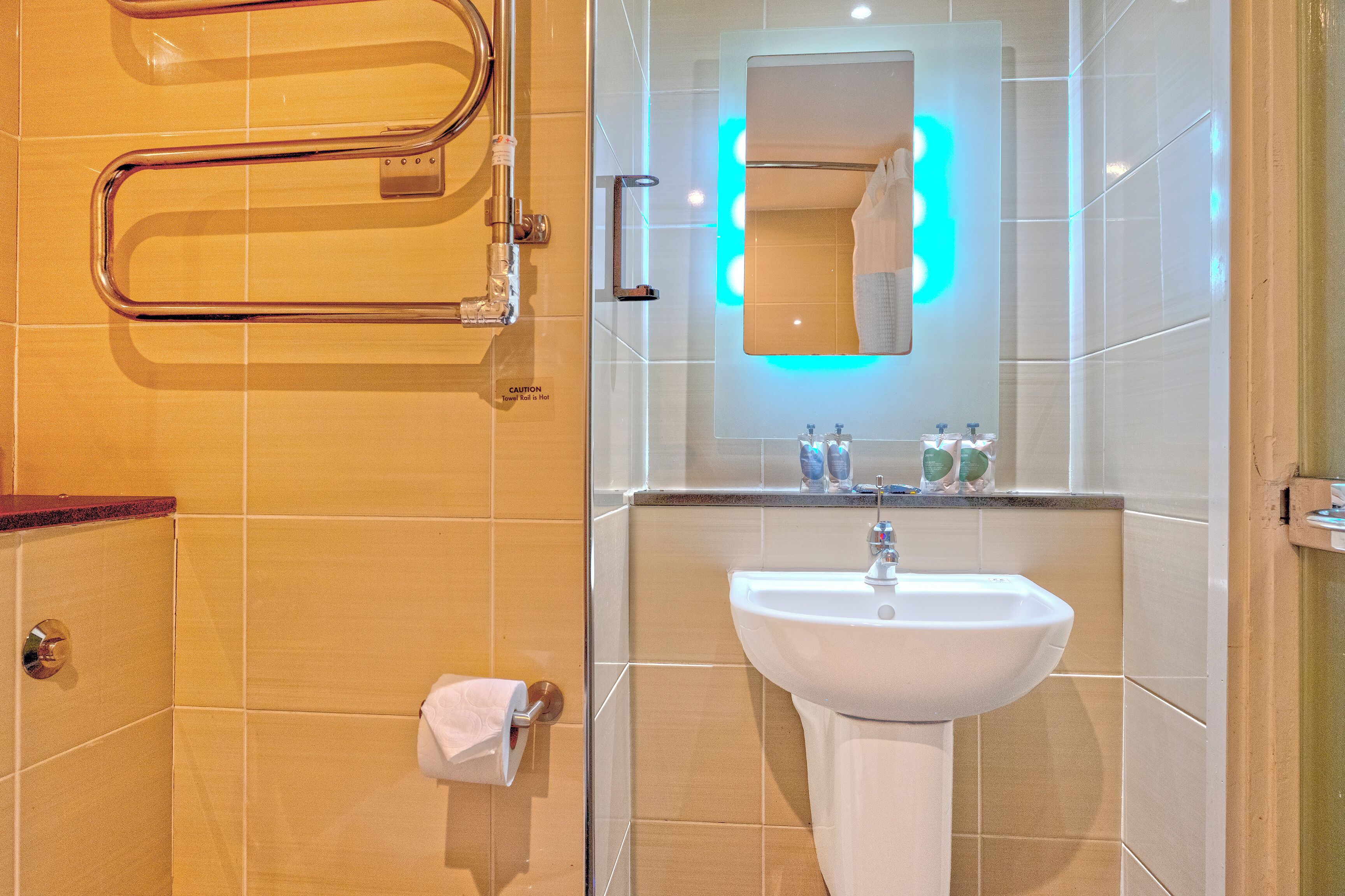 A bathroom with a white sink, a mirror, and a towel rack.