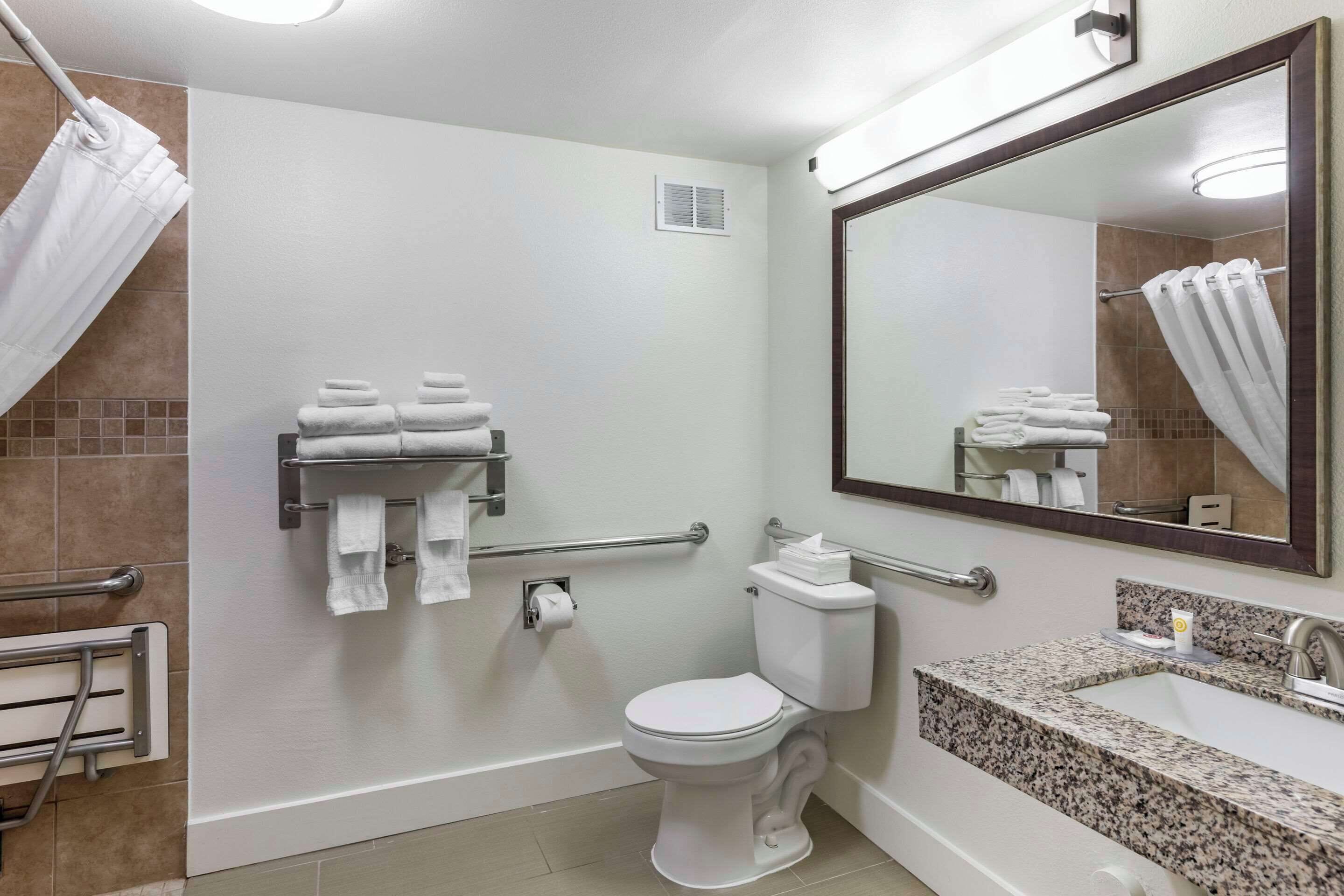 A modern bathroom with a toilet, sink, and towel rack.