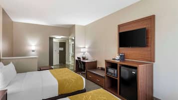 Quarto de hotel com duas camas, uma escrivaninha, televisão, micro-ondas e um pequeno frigorífico.