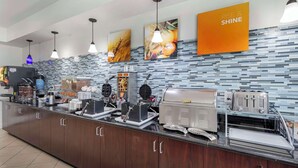 Una cocina moderna con una encimera amplia, equipada con varios electrodomésticos como cafetera, tostadora y calentador de alimentos.