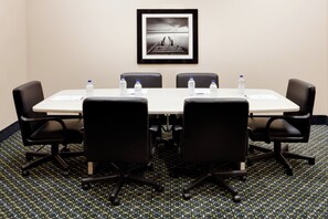 A conference room with a white table, black chairs, water bottles, and a framed picture on the wall. - Holiday Inn Express & Suites Smithfield - Providence by IHG (Smithfield)