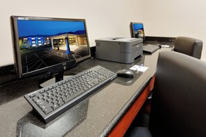 A hotel reception desk with a desktop computer, a printer, and a keyboard. - Holiday Inn Express & Suites Smithfield - Providence by IHG (Smithfield)