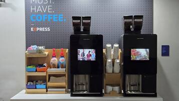 Una estación de café con dos máquinas de espresso, tazas de café y un letrero que dice 'MUST. HAVE. COFFEE. EXPRESS'.