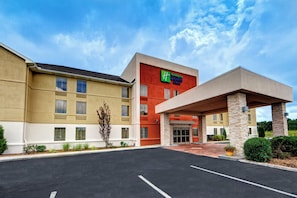 Een Holiday Inn Express & Suites hotel met een gebouw van twee verdiepingen, een overdekte ingang en een parkeerplaats.