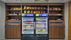 Two vending machines labeled 'Holiday Inn Express Cold Drinks and Snacks' and 'Holiday Inn Express Frozen Snacks' with various beverages and snacks inside. - Holiday Inn Express & Suites Crossville by IHG (Crossville)