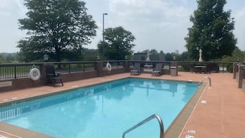 A swimming pool with a lifebuoy, lounge chairs, and a 'No Diving' sign.