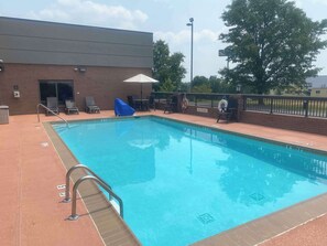 A rectangular pool with a metal ladder and a blue slide.